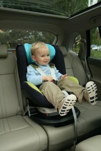 Toddler boy properly restrained in car seat