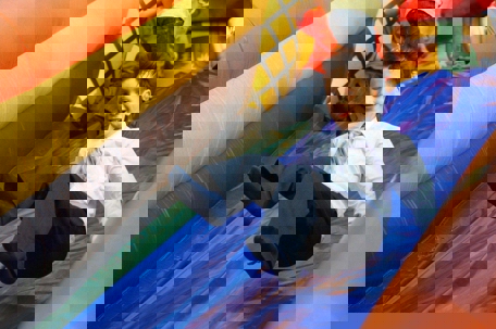 Boy on bouncy castle slide